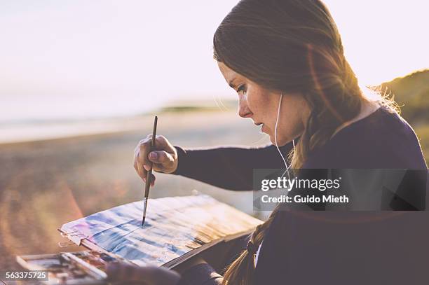 woman painting watercolour - eskapismus stock-fotos und bilder