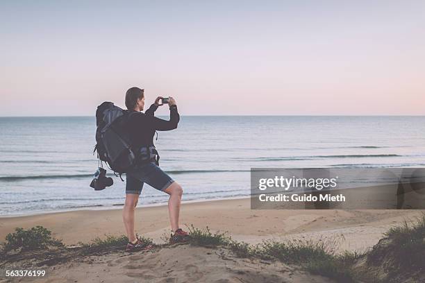 woman taking pictures at beach - longeville sur mer stock pictures, royalty-free photos & images