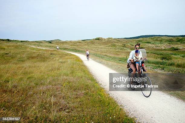 family on the bicycle through sanddunes in holland - vlieland stock pictures, royalty-free photos & images