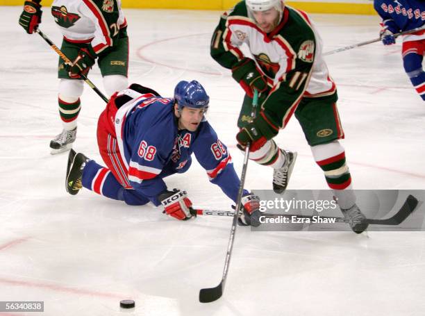 Jaromir Jagr of the New York Rangers tries to get the puck away from Pascal Dupuis of the Minnesota Wild in the second period on December 5, 2005 at...