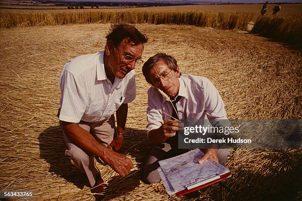 Researchers Pat Delgado and Colin Andrews examine a crop circle in a field near Salisbury, UK, 23rd July 1990.