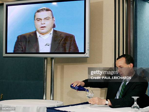 Washington, UNITED STATES: American Civil Liberties Union National Legal Team member Ben Wizner pours a cold drink during a press conference with...