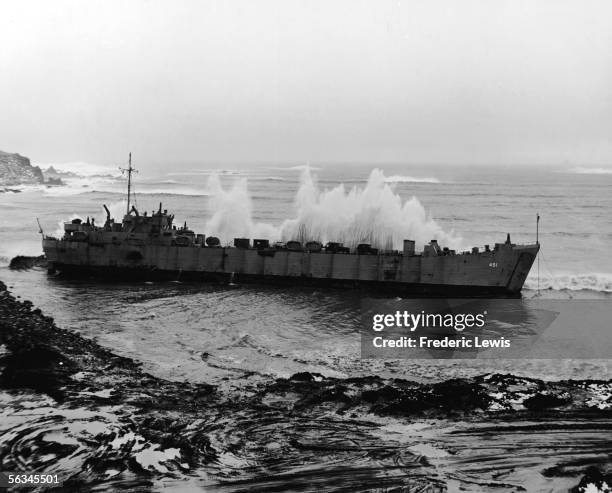 Large waves crash upon an American tank landing ship moored in an outpost in the Aleutian Islands, Alaska, February 29, 1944. The ship had been...