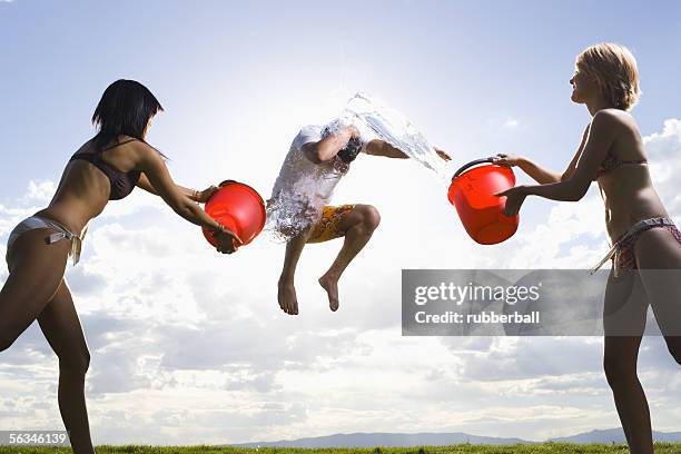 profile of two young women throwing water on a man - throwing water stock pictures, royalty-free photos & images