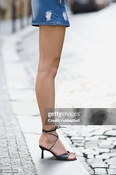 low section view of a young woman standing - bound in high heels stock-fotos und bilder