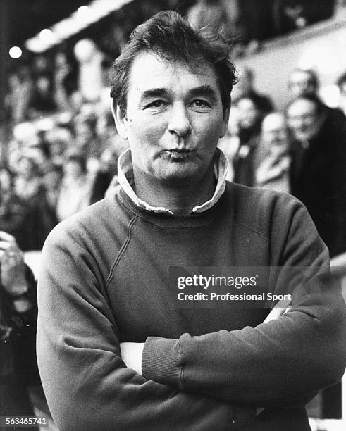 Nottingham Forest Football Club manager Brian Clough stands beside the pitch with his arms folded, circa 1984.