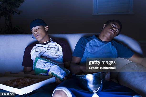 young men asleep in front of the tv - man sleeping with cap stock pictures, royalty-free photos & images