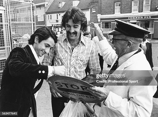 Argentnian World Cup winning football players, Osvaldo Ardiles and Ricardo Villa sign their autographs on the lollipop sign of a local 'lollipop man'...