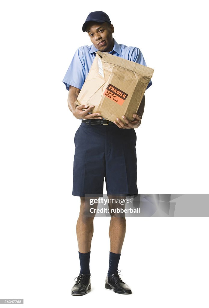 Portrait of a young man holding a damaged package