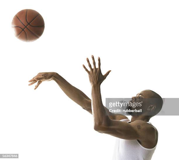 portrait of a young man throwing a basketball - tiro libre encestar fotografías e imágenes de stock