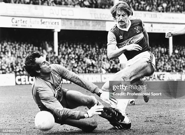 Tottenham Hotspur goalkeeper Ray Clemence dives at the feet of West Ham United's Neil Orr during a First Division match at Upton Park, London, April...