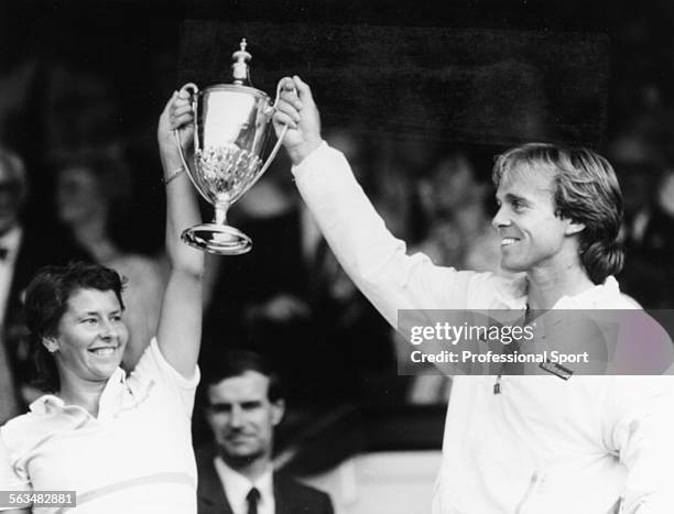 English tennis player John Lloyd and Australian tennis player Wendy Turnbull pictured smiling as they hold up their trophy in the Royal Box after...