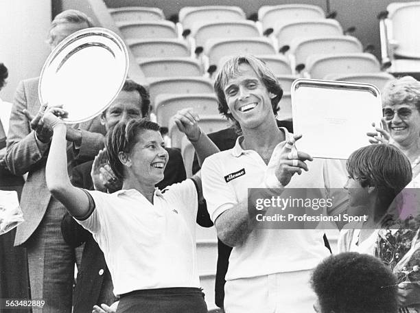 English tennis player John Lloyd and Australian tennis player Wendy Turnbull pictured together smiling as they hold their trophies after winning the...