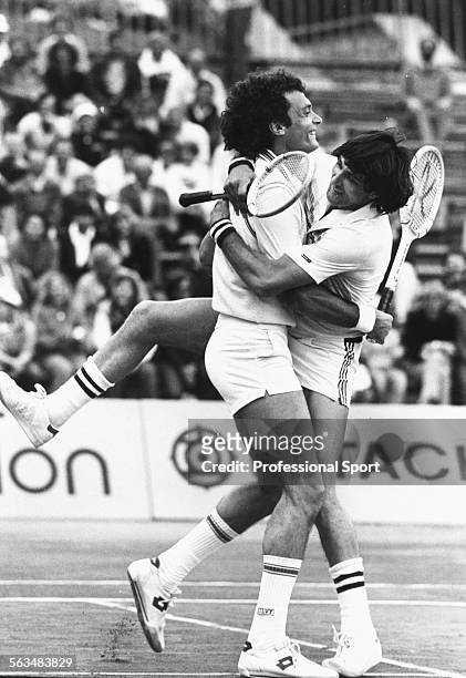 Men's doubles tennis partners Ilie Nastase of Romania and Jose-Luis Clerc of Argentina embrace during a match at the Monte Carlo Tennis Open in...