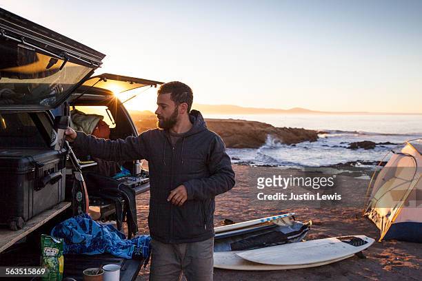 surfer prepares for day of adventure - bagageiro parte de veículo - fotografias e filmes do acervo
