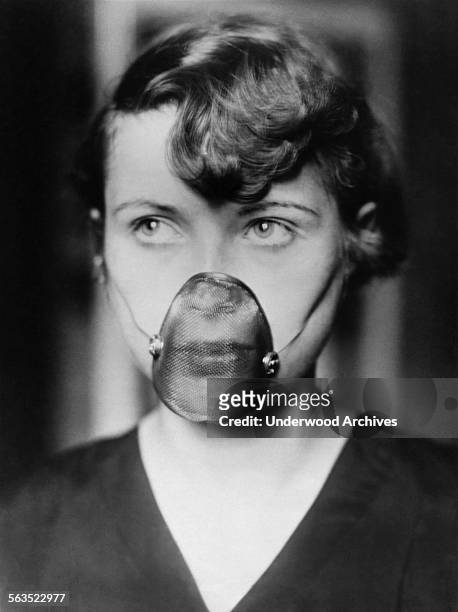 Woman wearing a new inhalation mask for treating catarrh of the nose and throat, circa 1930.
