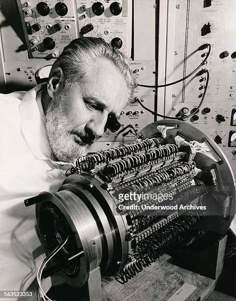 Hughes Aircraft Company engineer examines the 294 'read-write heads' that protrude from the outer cylinder of the Mark II, Mod 7 series, 15 million...