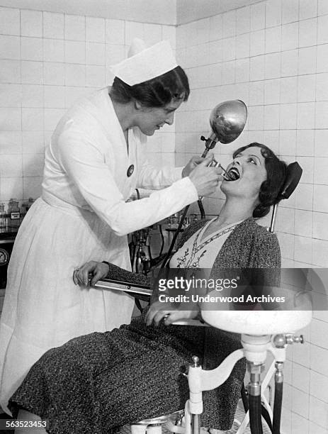 Motion picture patron at the Roxy Theatre gets treated for a sore throat in the movie theater's hospital, New York, New York, circa 1928. It can...