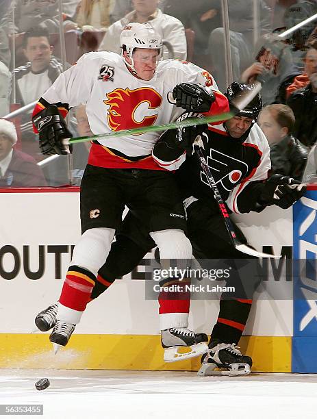 Dion Phaneuf of the Calgary Flames checks Donald Brashear of the Philadelphia Flyers on December 6, 2005 at Wachovia Center in Philadelphia,...