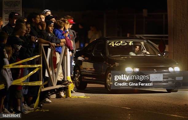 Race fans line the track near the start during legal street racing at Qualcomm Stadium in San Diego on Friday, Oct. 17, 2002.