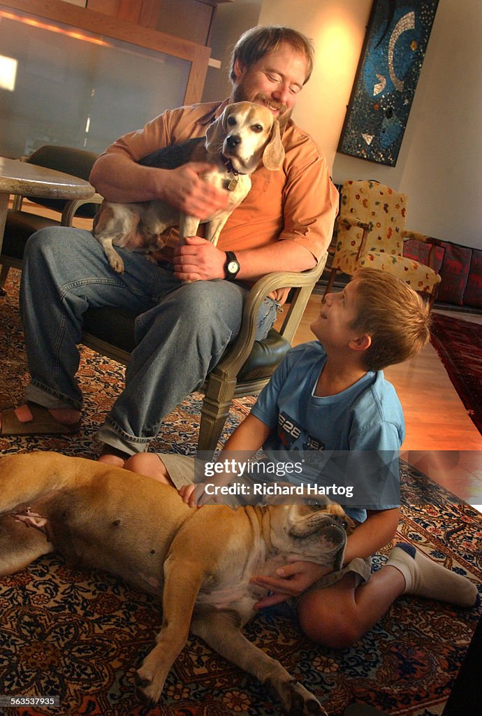 Ned Freed, top, and son Thomas spend some time together with their dogs in the living room of the re