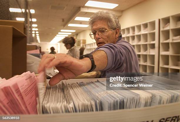 Don Morris collects absentee ballots to be counted, Wednesday at the Ventura County Hall of Administration. Preliminary results indicated that just...