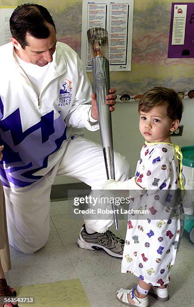 Tom Frost shares his torch from the 2002 Olympic Torch Relay with CHOC of Mission patient Cole Spicer of Laguna Niguel at the Mission Viejo Hospital....