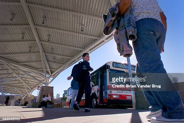 Bus riders head toward their rides at the new bus transfer station that recently opened in Santa Clarita Tuesday afternoon February 5 2002. DIGITAL...