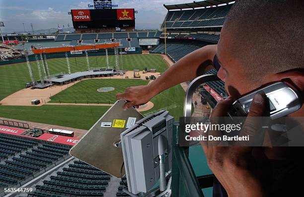 July 8, 2004. Anaheim. High above the infield stage at Anaheim Stadium, Christopher Blair fine tunes an antenna that will be used to broadcast this...