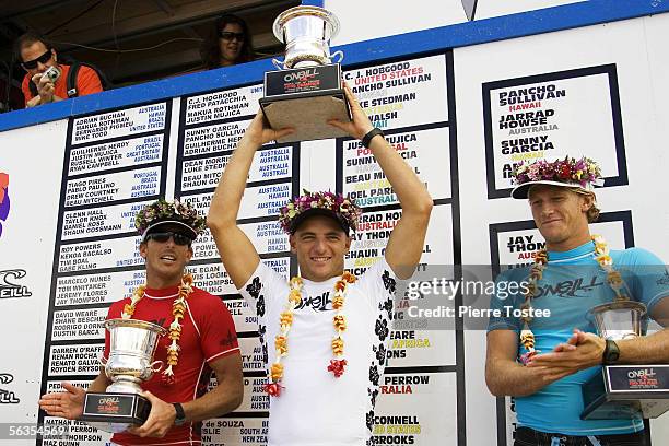 West Australian Jake Paterson of Yallingup, who placed first, celebrates on the podium with three time ASP world champion Andy Irons of Hawaii, who...