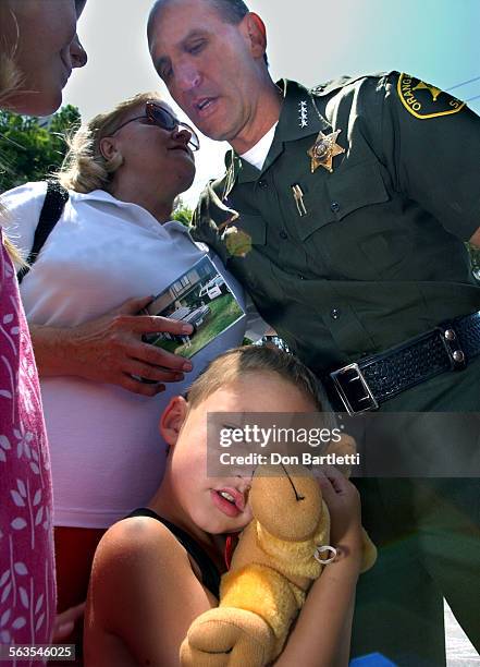 Orange County Sheriff Mike Corona consoles residents of the Smoketree Town Homes in Stanton at a public observation on the 1st anniversary of...