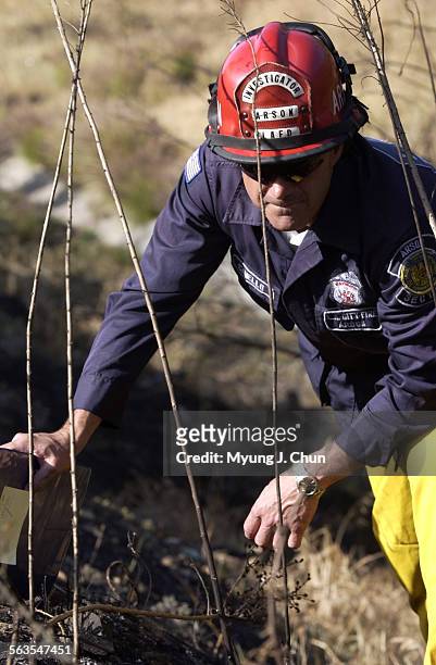 Los Angeles City Fire Arson Investigator Mike Camello looks for the cause of a smaller, second brush fire off the northbound 405 freeway near Getty...