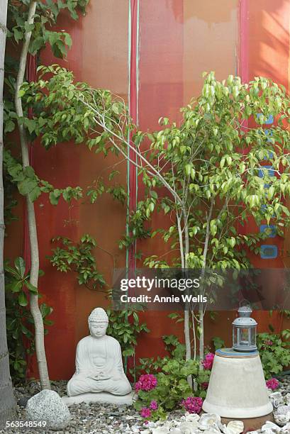 Two artists, Myrella Moses and Eric Mondriaan, have put together a home filled with fabric.  Detail of Buddha statue in portion of the entry patio...