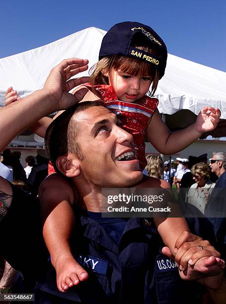 After the Commissioning Ceremony of Maritime Safety and Security Team 91103 one year old Paige Straky grabbed her father David Straky age 25's hat...