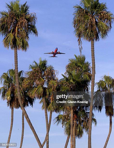 Jet takes off from John Wayne Airport framed by palm trees over Newport Beach's Back Bay. Facing regional air traffic pressures in the wake of El...