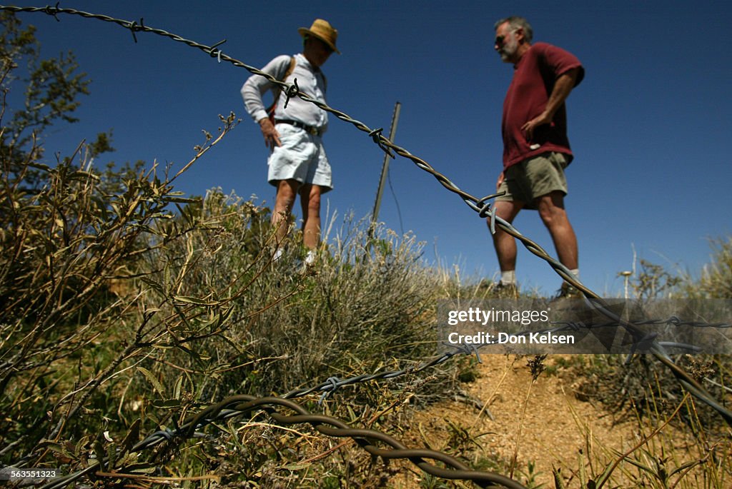 (Hesperia) Inspecting a barbed wire fence thats been illegally cut are Alden Sievers, former BLM (Bu