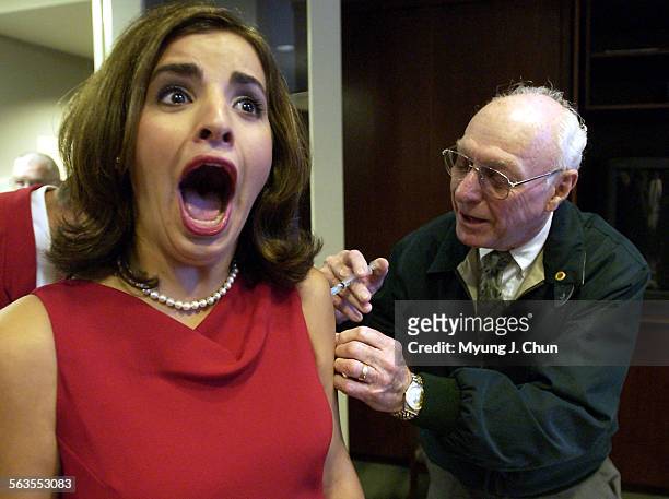 Rose Queen Alexandra Wucetich reacts to a flu shot given by doctor Ray George Tuesday morning at the Tournament House in Pasadena. Dr. George is a...