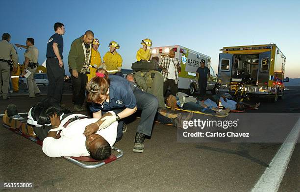 Paramedic talks with one of the victims of a two bus collistion on the South bound 15 HWY just north of Baker Ccal. Suday night. The tour buses where...