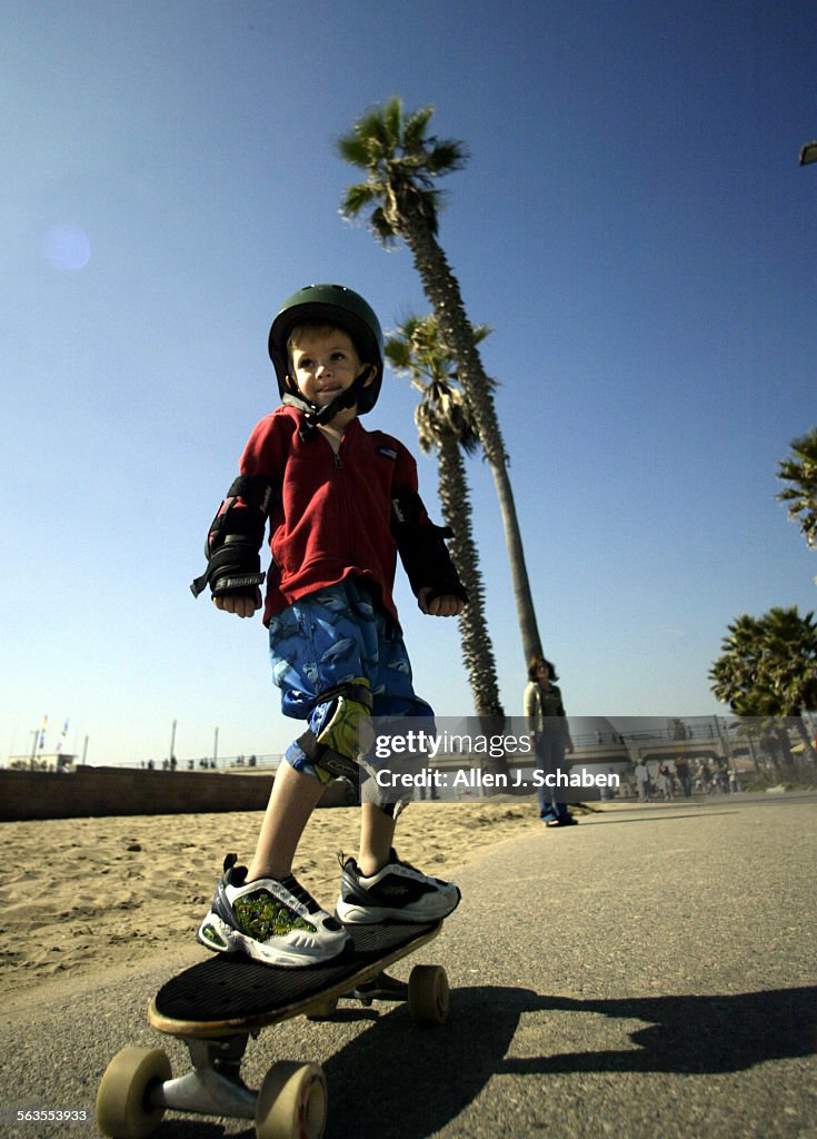 Chase Mann Green, 4, of Telluride, CO, rides his skateboard along the boardwalk at the Huntington Be