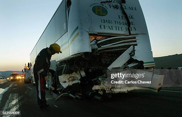 Heavey Rescue tec from Clark County Fire Dept., inspects the damage of one of the buses involved in a collistion on Hwy 15. Two tour bus hit on the...
