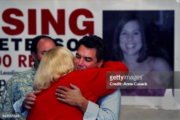 Scott Peterson gets a hug from his sister in law Alison Peterson from San Diego who arrived to help distribute posters. Laci's photo is on poster in...