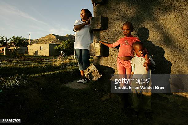 Alice Foulo Ntoi stands outside of her home of her home several kilometers outside of Maseru, the capital of Lesotho, with her son Germond right, and...