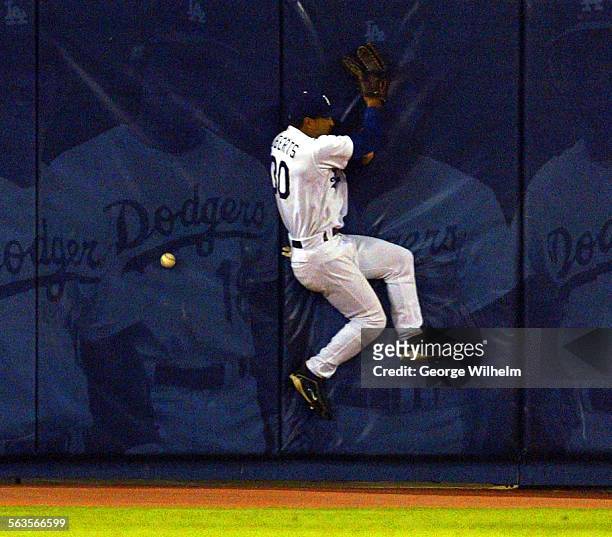 Dodger centerfielder Dave Roberts hits the wall trying to catch up to a hit by Arizona Diamondback's Alex Cintron in the 4th inning at Dodger Stadium.