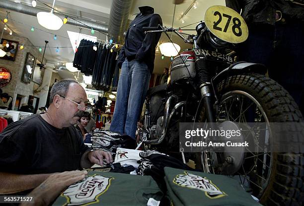 Richard Ramsey from Huntington Beach had already purchase the book and looks to buy a tshirt. Steve McQueen mortorcycle is above right.A book...