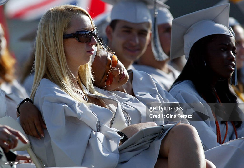 Indah Datau rests her head on the shoulder of classmate Alison Cristofar at Grant High School gradua