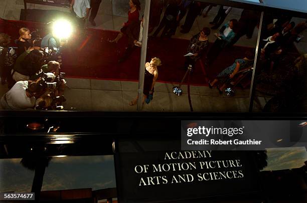 Photographers clamor to photograph Mena Suvari as she arrives at the red carpet for the west coast premier of "The Road to Perdition," at the Academy...