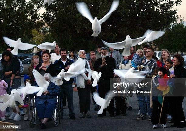 Participants react as doves are released before a march titled "Lights for Little Lives" to remember the nine children killed in the Christmas Day...