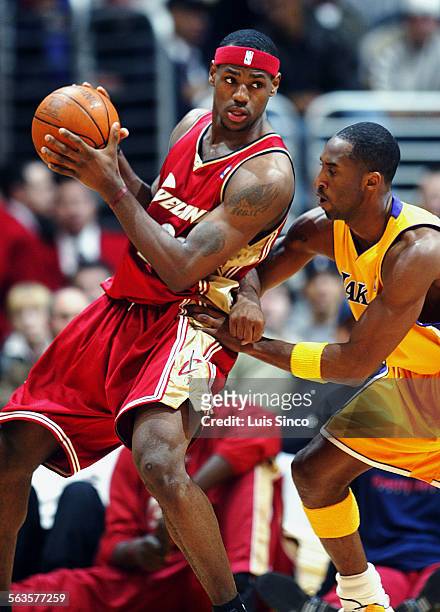 Cleveland Cavaliers guard LeBron James backs in on Laker Kobe Bryant in the first half Monday at the Staples Center.