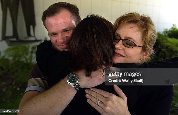 Molestation victims from left Matt Severson, Mary Grant and Kathleen Noble hug each other after a press conference outside Parker Center in Downtown...