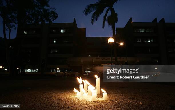 Twilight looms over Martin Luther King Jr./Drew Medical Center as candles from an afternoon vigil melt away in September 2004. The hospital faces an...